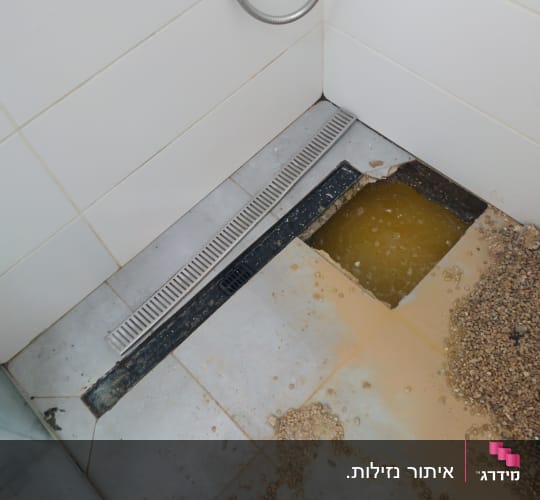 רצפת מקלחת עם חור ורטיבות גלויה